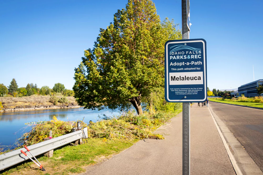 a sign on the Idaho Falls green belt that states Melaleuca adopted the path.
