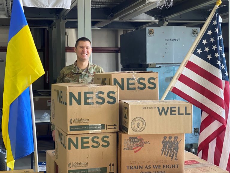 A man behind boxes of Melaleuca Products