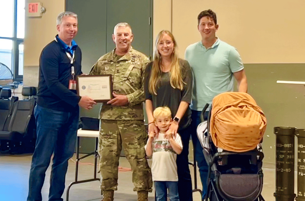 Major General Michael Garshak presented the Patriot Award to Melaleuca IT Director James Andersen, Sgt. Stephen Herriott, his wife Emily, and their two children